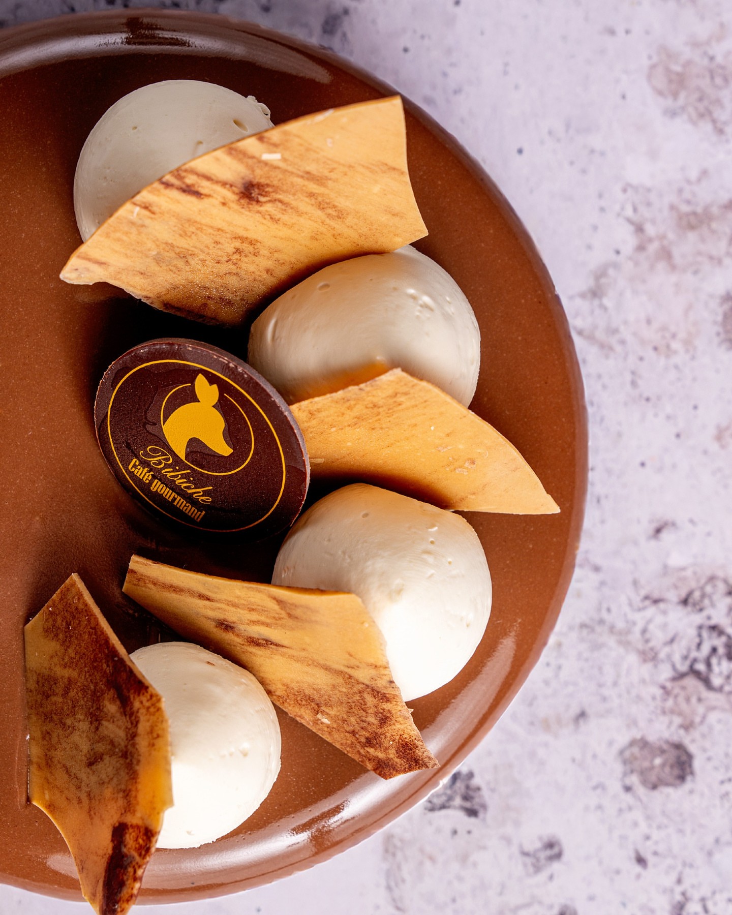 Maurice est l'entremet qui vous réchauffe cet hiver ❄️\n\nEntre le croustillant amande-noisette, le gianduja fondant, le chocolat blond et la tonka... chaque bouchée nous fait oublier l'hiver ! 😋\n\nDisponible en 4 ou 6 parts, à venir chercher en boutique ou à réserver !\n\n📸 @agence_grandbruit #bibiche #caen #patisserie #chocolat #délice